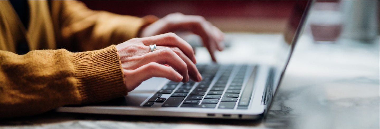 Person types on a laptop keyboard