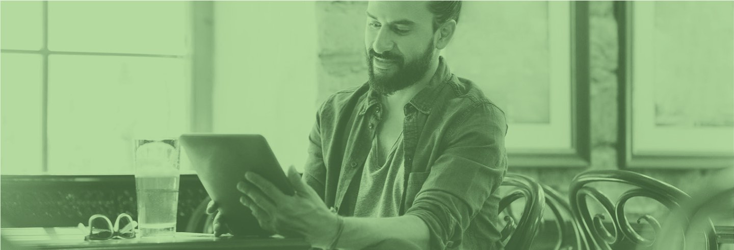 A man with a beer works on a tablet