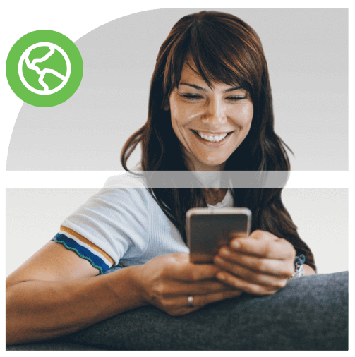 Person smiling sitting on couch holding her mobile device.